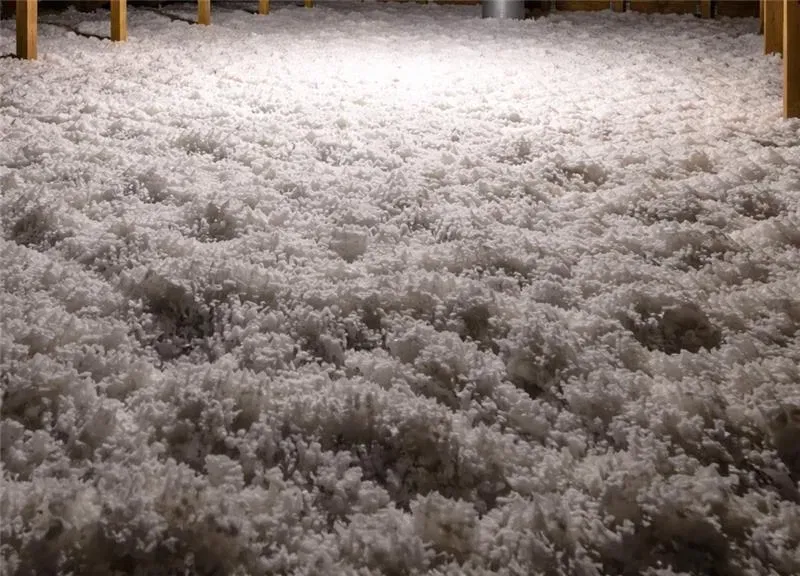 Uniform blown-in fiberglass insulation covering an attic floor